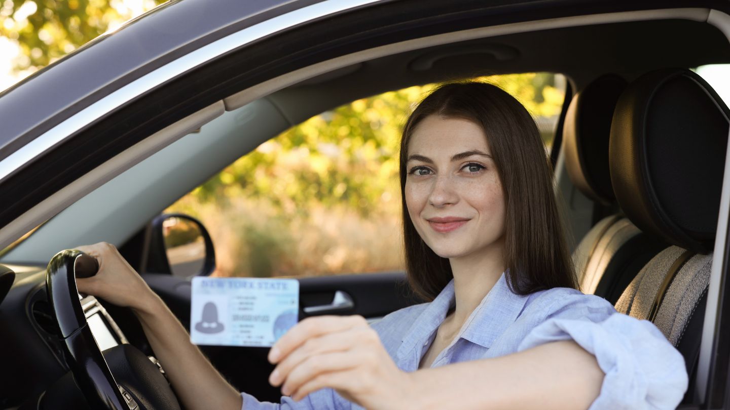 Woman Holding Her Driver's License While Sitting In Car